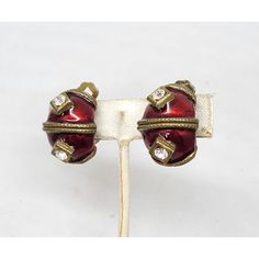 This is part of Chairish’s Costume Jewelry assortment.  1980s goldtone red enamel with round clear rhinestones half hoop clip earrings. Marked "YOSCA©." Measure: 1 inch long by 3/4 inches wide. Condition: Very good; some darkening to metal on backs. The matching cuff bracelet is also available for purchase. Red Round Clip-on Jewelry, Vintage Red Enamel Earrings, Vintage Red Clip-on Earrings, Luxury Vintage Red Clip-on Earrings, Luxury Vintage Enamel Clip-on Earrings, Clip Earrings, Clear Rhinestones, Costume Jewelry, Cuff Bracelet