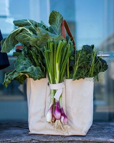 a bag filled with lots of green vegetables