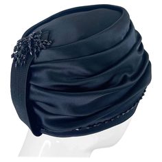 Chic 1960s YVES SAINT LAURENT black silk / satin beaded turban hat ! Features hand-sewn black beads around the brim, and on the band on the back. Couture quality, with exceptional attention to details. Can easily be dressed up or down. Pair with jeans and a tee, or a dress. The possibilities are endless with this collectors piece. In great condition Made in France Measurements: 21.75 inches inner circumference Turban Hat, Hats For Sale, Vintage 60s, Black Silk, Black Beads, Silk Satin, Yves Saint Laurent, Hand Sewing, Accessories Hats