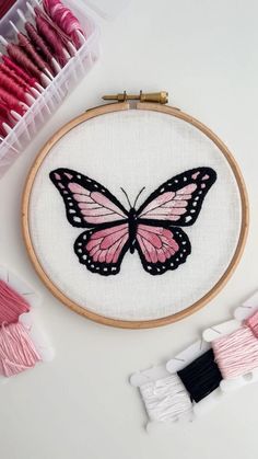 a pink and black butterfly sitting on top of a white table next to some scissors