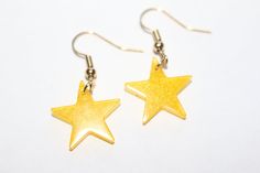 pair of gold star earrings on white background