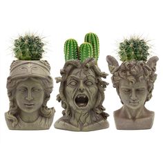 three statues with cactus heads on their heads