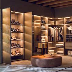 a walk in closet filled with lots of shoes and bags next to an ottoman on the floor