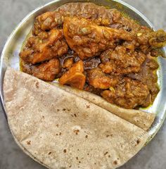 a close up of a plate of food with meat and tortilla wrap on the side