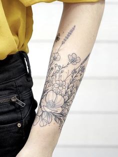 a woman's arm with flowers on it and an arrow in the middle is shown