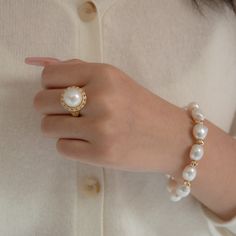 This classic ring is made with our signature 12-13mm AA perfect round white Edison Pearl. The pearl is in perfect round shape with very high quality of luster. Surrounded by a circle of small pieces of zircons on 14k gold vermeil band. Pearl Type: Freshwater Edison Pearls Pearl Quality: AA [Shape]: Round Pearl [Pearl Size]: 12-13mm [Blemish]: Minimal [Luster]: Relatively High Ring Size: Open ended adjusted from 6 to 8 (US/Canada sizing) Metal material: 14k Gold Vermeil Note: Every pearl is uniqu Elegant White Oval Dome Ring, Luxury Round Pearl Drop Ring, Luxury Round Ring With Pearl Drop, Elegant White Pearl Ring With Round Band, Elegant White Pearl Ring, Luxury Pearl White Round Pearl Ring, Luxury Round Pearl White Ring, Timeless White Pearl Ring, Pearl Drop Diamond Ring