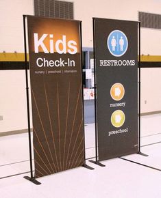 two signs that say kids check - in and restrooms