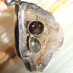 Jumbo Agate Druzy .925 Pendant With Bezel-Set Smokey Quartz & Tourmalinated Quartz (Quartz With Black Tourmaline Needle Inclusions) In The Hollow Of The Druzy Slice. Works As A Sweater Necklace On A Thick Chain, Or On A Choker For A Bold Look. Gorgeous Statement Piece Of Fine Jewelry In Sterling Silver. This Ooak All-Natural Gemstone Pendant Is A Great Gift For Mother's Day, Graduation, Or Just Because. I'm A Certified Gemologist So Shop With Confidence! Bundle For Best Deal. Wood Slice Necklace, Sweater Necklace, Gold Chain Choker, Tourmalinated Quartz, Bubble Necklaces, Quartz Crystal Necklace, Initial Pendant Necklace, Beaded Statement Necklace, Faux Pearl Necklace