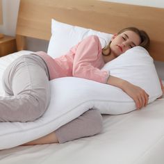 a woman laying on top of a white pillow