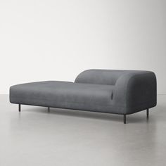 a gray couch sitting on top of a white floor next to a wall and window