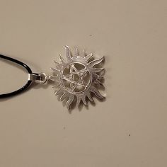 a pentagramil pendant on a black cord