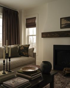 a living room filled with furniture and a fire place in front of a large window