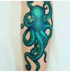 an octopus tattoo on the leg of a person with green ink and blue watercolors