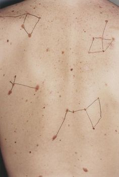 the back of a person's stomach with brown spots on it and small stars in the middle