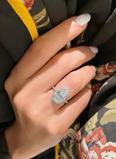 a woman's hand with a diamond ring on it