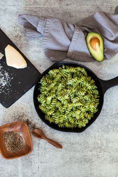 spinach pasta with avocado sauce in a cast iron skillet on a table