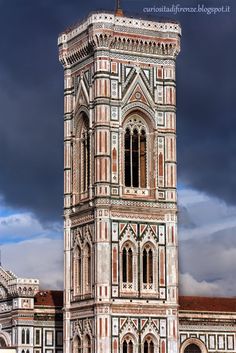 a tall tower with a clock on it's side against a dark sky background