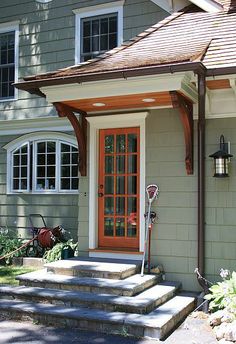 the front door of a house with steps leading up to it and a red door