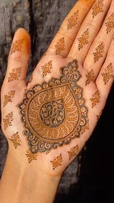 a woman's hand with henna tattoos on it