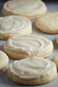 cookies with frosting sitting on a baking sheet