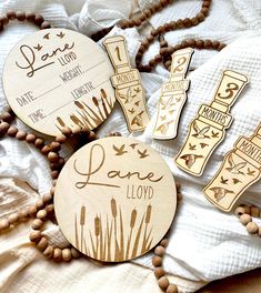 some wooden tags that are laying on a bed with bead necklaces and beads