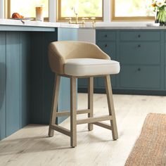 a kitchen with blue cabinets and white countertops is pictured in this image, the stools are upholstered