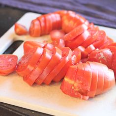 sliced up tomatoes on a cutting board ready to be cut into wedges or strips