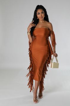 a woman wearing an orange dress and holding a purse