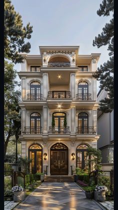 a large white house with lots of windows and balconies on the second floor