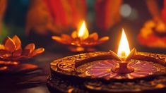 a lit candle is sitting on a table with other candles in the background and decorations around it