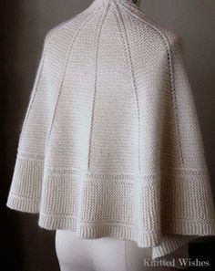 a white knitted cape on a mannequin head