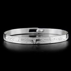 This elegant silver clasp bracelet has been hand crafted by Coast Salish artist Gilbert Pat using sterling silver. There are two depictions of the Raven that have been craved into the surface of the band. Band width is 1/4" and length is 7 1/2". EAGLES SYMBOLIZE: POWER, INTELLIGENCE, VISION The Eagle is one of the most popular in Native art and mythology. In many regions, Eagle clan families are traditionally very prominent and Eagle Chiefs are the most powerful. Eagle is used to represent perce Adjustable Hallmarked Sterling Silver Bracelet For Ceremonial Occasions, Classic Etched Sterling Silver Bracelet, Classic Etched Bracelets As A Gift, Classic Etched Bracelets As Gift, Classic Etched Sterling Silver Bracelet As Gift, Etched Sterling Silver Bracelet As Gift, Etched Sterling Silver Bracelet Gift, Ceremonial Sterling Silver Round Bracelets, Engraved Adjustable Sterling Silver Bracelet