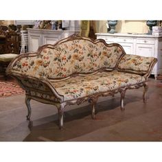 an ornately decorated couch sitting on top of a wooden floor next to a dresser