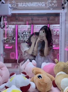 a woman taking a selfie in front of stuffed animals