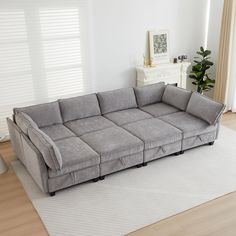 a large gray couch sitting on top of a white rug