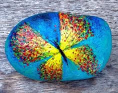 a painted rock sitting on top of a wooden table