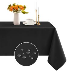 a black table cloth with white circles on it and flowers in a vase next to it