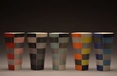 five different colored cups lined up in a row