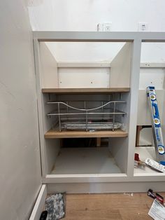 an unfinished room with shelves and tools on the floor