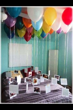 balloons are floating in the air over a table with pictures and photos on it's sides