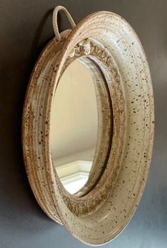 a round mirror mounted to the side of a wall