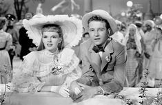 the man and woman are posing for a photo in front of many people wearing hats