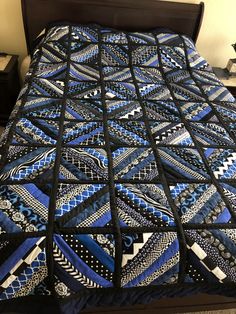 a bed with a blue and black quilt on it