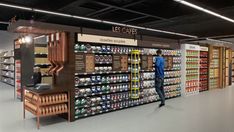 a man standing in front of a store display filled with lots of drinks and beverages