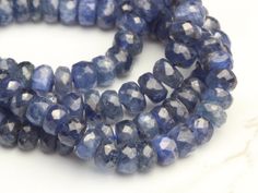 two strands of blue glass beads on a white surface