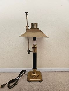 an old fashioned lamp is sitting on the floor