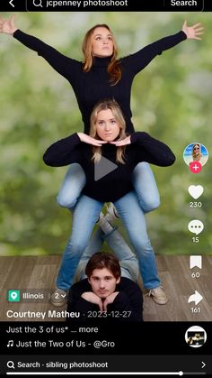 two people are sitting on top of each other with their hands up in the air