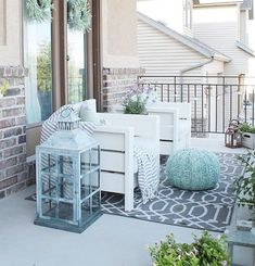 the porch is decorated with white furniture and green plants