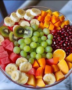 a fruit platter with grapes, bananas, kiwis, oranges and pomegranates