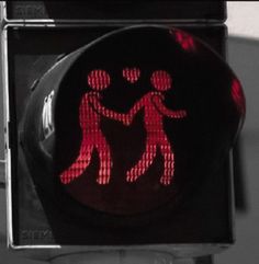 a red traffic light with an image of two people holding each other's hands